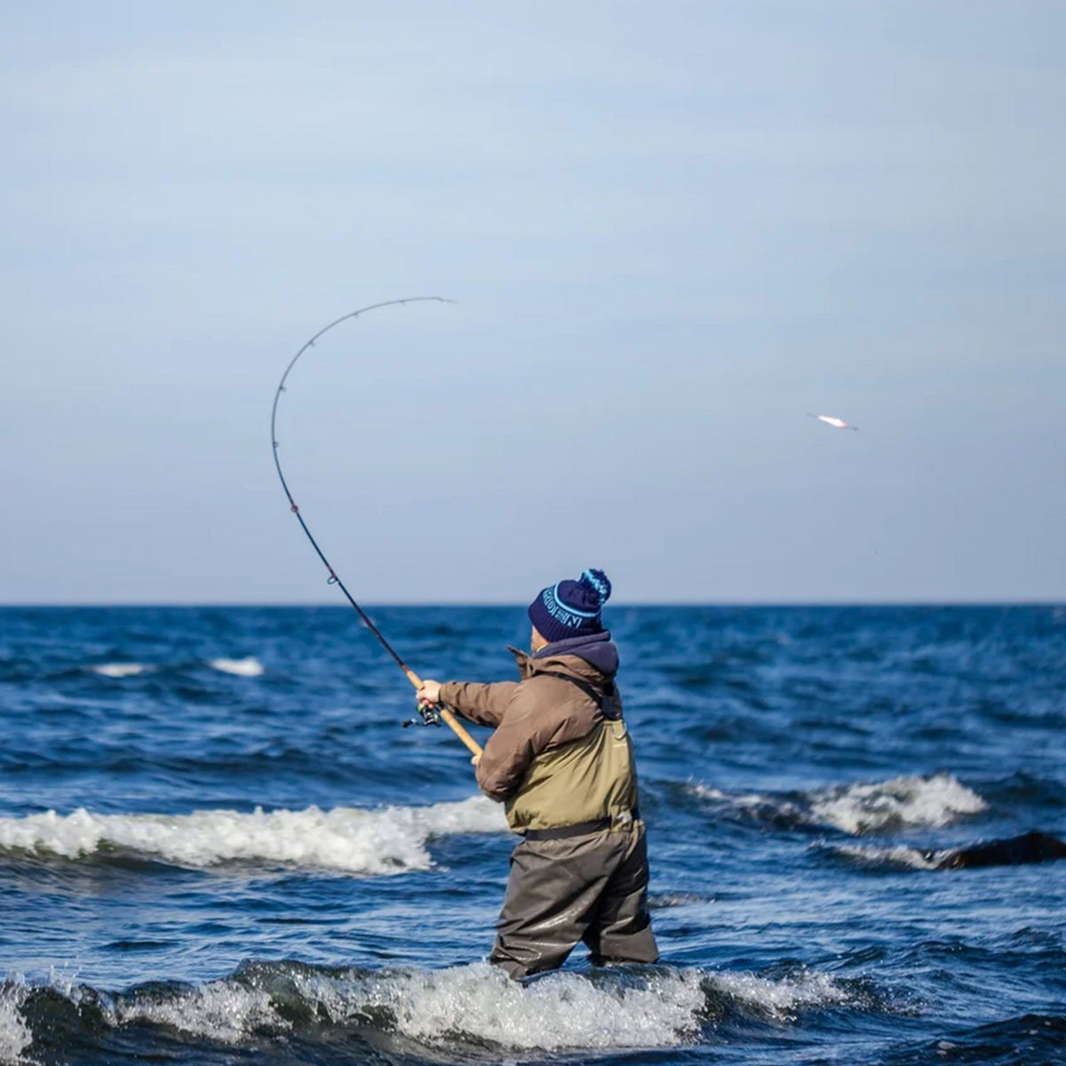 Sportfiskare i vadare kastar med spinnspö i havet vid Gotland