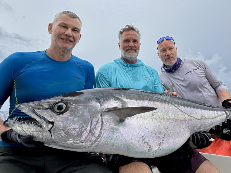 Tre sportfiskare visar upp dagens dogtooth tuna i Indiska oceanen på fiskeresa till Rodrigues Ilands